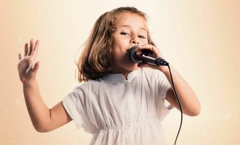 Young girl singing into a microphone, fully focused during a music lesson