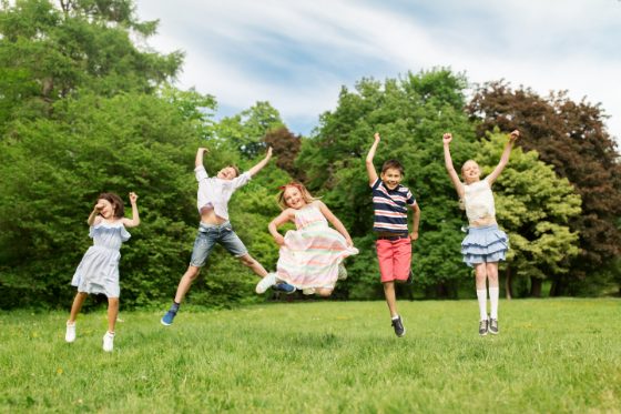 Kids jumping and playing outdoors in a Greater Boston park
