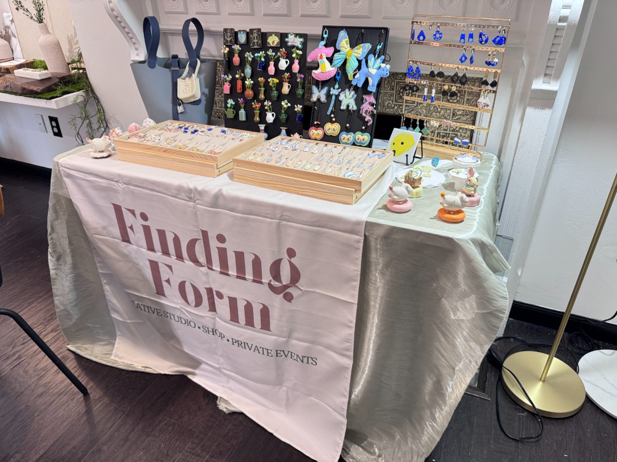 The Finding Form table with its banner, handmade jewelry, charms and small ceramic figures